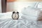 Analog Alarm Clock on Bedroom in Modern House, Retro Timer at 7.00 a.m. on White Cover Bed