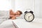 Analog alarm clock. Woman sleeping in bed