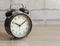 Analog black alarm clock on the table