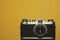 Analog camera on yellow background. copy space