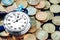 Analog stopwatch and pile of gold coins on a black background close-up. Counting time by stopwatch. Time measurement