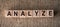 Analyze - word written on wooden blocks over brown background