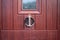 An anchor and ships wheel door knocker on the front of a brown door