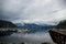 The anchor yacht in harbor. empty Pier.  After rain cloudy sky, misty forest mountains and calm water.