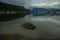 The anchor yacht in harbor. After rain cloudy sky, misty forest mountains and calm water.