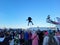 Anchorage, Alaska, USA - March 4 2023: Blanket toss at the Fur Rendezvous carnival. Girl captured middair.