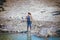 Anchorage Alaska USA - Woman in rubber boots and fishing vest fishes for salmon in Ship Creek near downtow