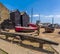 Anchors, net drying sheds and Fishing boats beneath a blue sky at Hastings, Sussex, UK