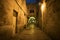 Ancient alley in Jewish Quarter at night time, the old city Jerusalem. Mystical atmosphere of deserted road leading to an old city