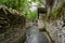 Ancient alleyway with stone-stacked walls in cloudy spring