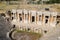 Ancient antique amphitheater in city of Hierapolis in Turkey. Steps and antique statues with columns in the amphitheater