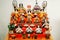 Ancient antique `Hina Matsuri` dolls in kimonos show on shelf and red velvet.