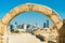 Ancient arch at Bahrain Fort with skyline of Manama. A UNESCO World Heritage Site