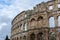 Ancient architecture of Amphitheater Arena in Pula under cloudy sky