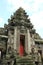 Ancient Balinese carved stone temple entrance with red door