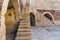 Ancient brick building with two shabby stone stairways and two crumbling arched alcoves on street