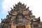 Ancient brick and stone temple with intricate carved ornamental details in silhouette against the sky in Bali Indonesia