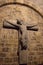 Ancient broken statue of Jesus Christ on the wall. Medieval stone cross in medieval church. Ancient crypt decoration.