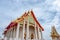 Ancient buddhist chapel with Thai motifs decorated with blue sky