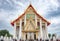 Ancient buddhist chapel with Thai motifs decorated with blue sky