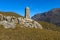 An ancient burial on the mountainside. A small pyramid of hewn stones against the backdrop of the blue sky