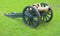 An ancient cannon against a green grass