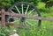 Ancient cartwheel near a wooden fence