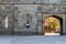 Ancient castle city wall. Arched medieval gate in a stone wall. Sun shining through the stone arch.