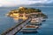 Ancient castle on Pigeon Island in Kusadasi Turkey with tourists boats