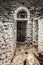 Ancient cave entrance with abandonned door between stone walls