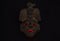 An ancient ceramic pre columbus mask based in American indigenous tribes art iluminated by red light inside