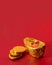 Ancient Chinese Gold Ingot with Three Golden Coins Made From Alumunium Foil on Red Background For Chinese Lunar New Year Greeting