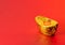 Ancient Chinese Ingots Money From Gold Aluminium Foil For Chinese Lunar New Year Greeting Card with Red Background. Symbol of Pros