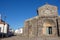 Ancient church in medieval village in Spain. Old stone church with open entrance. Catholic cathedral on clear blue sky background.