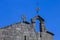 Ancient Church Roof with a Knight Wind Vane against a Clean Blue Sky.