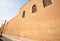 Ancient clay wall of the building with the shadow from electrical wires in the town