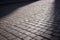 The ancient cobblestones are partially illuminated by the sun\\\'s rays in a slight refocused