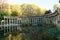 The ancient columns of Parc Monceau are reflected in the water of the oval basin, in the sun . This public garden is located in