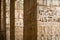 Ancient columns in a row with carved egyptian hieroglyphics