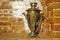 Ancient copper samovar stands in the form of scenery on the background of the fireplace wall of red brick. Background, retro,