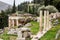 The ancient Delphi city in Greece with Treasury of Athenians and historical ruins of columns