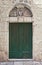 Ancient door painted green with architrave