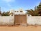 Ancient Egyptian house with old white cement wall and wooden door. Oasis and Berber constructions in the desert