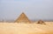 Ancient Egyptian pyramids of Giza against sandy sky