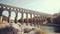Ancient Elegance: Majestic Roman Aqueduct Crossing Tranquil River Waters