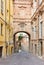 Ancient, empty street with red bricks building and arch in Mondovi, Italy