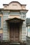 An ancient European facade. Porch in vintage style with a small roof and a wooden old door