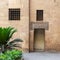 Ancient external old decorated bricks stone wall with two windows and opened door