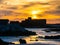 Ancient fort sunset silhouette with flying gulls and dramatic sky in Essaouira in Morocco