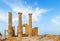 Ancient Greek pillars at Lindos acropolis with blue cloudy sky in the background